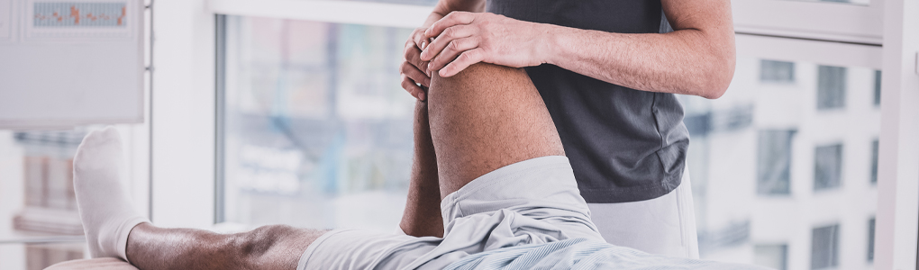 A sports medicine specialist diagnosing a knee injury.